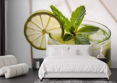 Close view at a mint and lime with cold fresh lemonade drink with slice of lime on the glass slices of lime and mint leaves on a white wooden background Wall mural