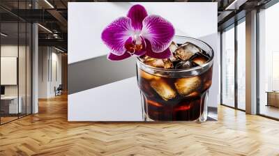 Glass of cola with ice cubes and purple orchid Wall mural