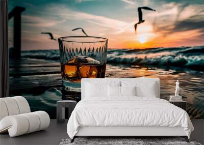 Glass of whiskey with ice on the rocks near the sea selective focus Wall mural