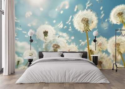 Dandelion seeds blowing away across a blue sky, spreading for a new life Wall mural