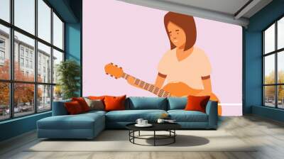 Young woman is playing acoustic guitar in an online learning video Wall mural