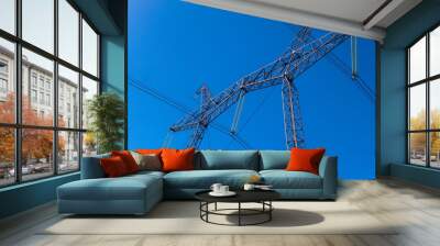 Power Transmission Tower. Air hi-voltage electric line supports on a blue sky background. Electricity garlands and insulators with electric wires on a top steel mast support. Wall mural