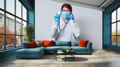 Doctor wearing surgical face mask and gloves. Wall mural