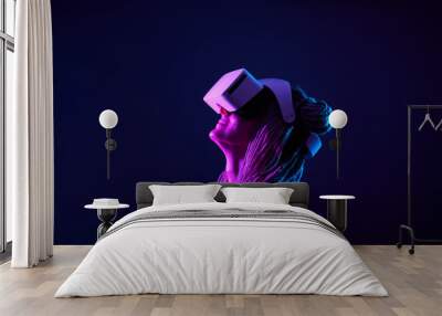 Woman is using virtual reality headset. Neon light studio portrait. Wall mural