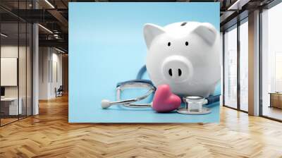 piggy bank with stethoscope and heart isolated on light blue background with copy space. health care Wall mural