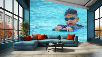 Asian boy learned to swim in the pool. Wall mural