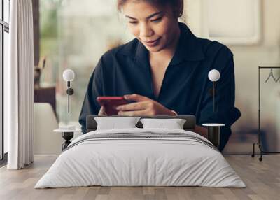 Asian woman working in cafe and using smart phone. Wall mural