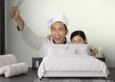 Funny Asian chef holding spatula for battle with food together, lifestyle concept. Wall mural