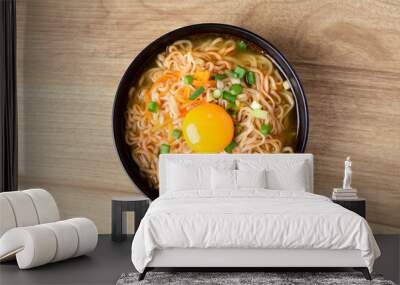 Asian instant noodle soup with fresh egg yolk on wooden background, Table top view Wall mural