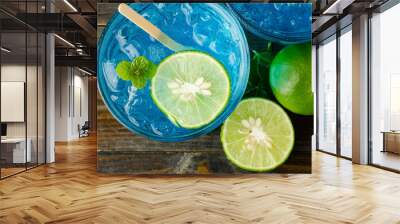 Ice blue drink with lemon on wooden background Wall mural