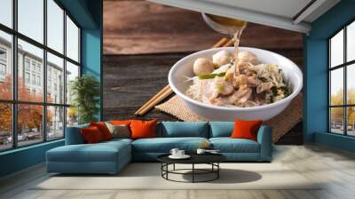 Rice noodles soup with pork and pork ball in a bowl with ladle pouring soup water, Thai noodles soup Wall mural