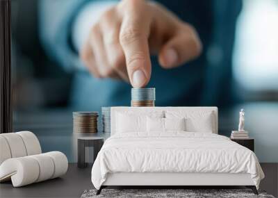 Close-up of a person stacking coins in ascending order, symbolizing financial growth, investment, and savings, with a blurred background. Wall mural