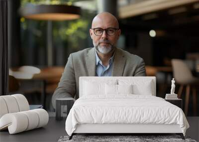 A businessman sits in his office holding a tablet Wall mural