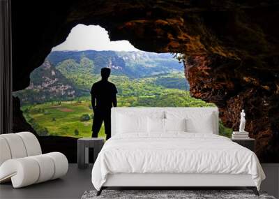 Adventurous tourist men looking through a cave opening through green scenery.  Window Cave (Cueva Ventana) near San Juan Puerto Rico, USA. Wall mural