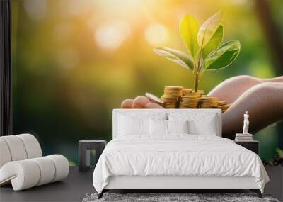 A hand holding a plant with a pile of coins on top of it Wall mural