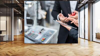 hand close-up photo Male and female engineers use tablets to check machine systems. There are electronic circuit boards in plastic and steel industries waiting to be shipped to customers. Wall mural