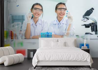 Two Asian female researchers are scientists in a biology lab. Manufacture medicines with solutions in test tubes Business industry, pharmaceutical manufacturing company, medical, pharmaceutical Wall mural