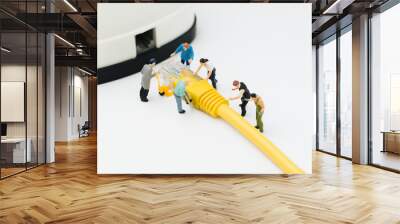 Internet network, telecommunication connecting people concept, group of miniature people figures help moving LAN, Local Area Network yellow cable line to connect with router device Wall mural