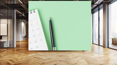 White clean calendar with black pen on pastel green background with copy space using as reminder, schedule, meeting agenda and work planning concept Wall mural