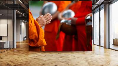 Buddhist monk holding alms bowl waitting for buddhism make merit by offering food and water at morning Wall mural