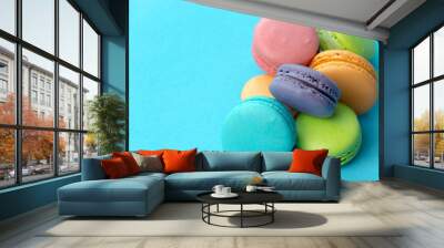 Close-up of macarons cakes of different colors in blue background. Culinary and cooking concept. Tasty colourful macaroons. Wall mural