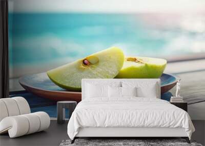 Green Apple on Wooden Plate with Ocean in Background. Wall mural