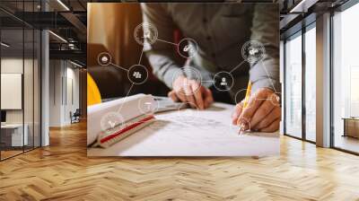 business man hand working and laptop with on on architectural project at construction site at office desk in office Wall mural