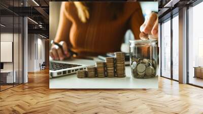 businessman holding coins putting in glass with using smartphone and calculator to calculate  concept saving money for finance accounting Wall mural