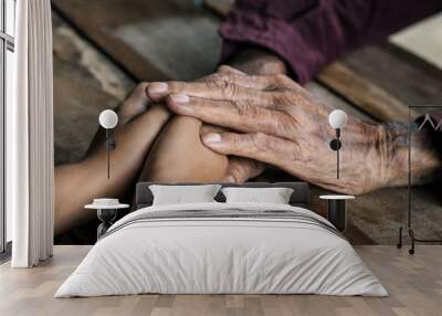 Hands of the old man and a child's hand on the wood table
 Wall mural