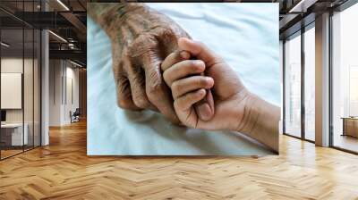 Hands of the old man and a child's hand on the wood table Wall mural