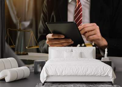 justice and law concept.Male judge in a courtroom  the gavel, working with smart phone and laptop and digital tablet computer on wood table in morning light 
 Wall mural