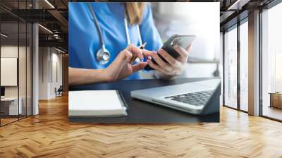 Medical technology concept. Doctor working with mobile phone and stethoscope in modern office Wall mural