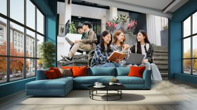 Three young Asian college students and a female student group work at the campus park Wall mural