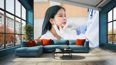 Beautiful young asian woman getting cosmetology treatment facial skin injection by doctor in beauty clinic. Wall mural