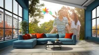 Happy family playing on the grass in the park at sunset. The concept of a happy family. Wall mural