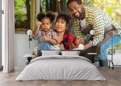 Portrait of African man and wife teaching the children to raising chickens in farm Wall mural