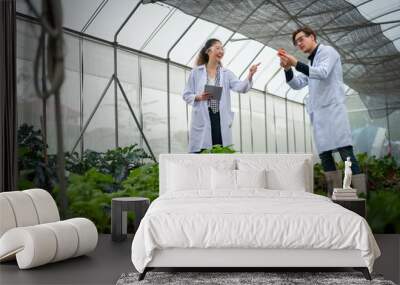 Portrait of Man and Woman agricultural researcher holding tablet while working on research at plantation in industrial greenhouse Wall mural