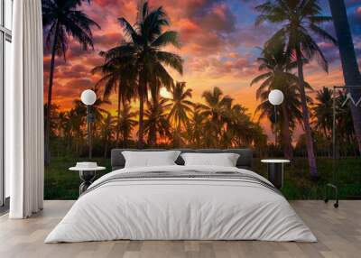 Silhouette coconut palm trees on garden at sunset. Vintage tone. Wall mural