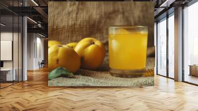 A close-up of quince fruits and a glass of quince alcohol drink on a canvas background, showcasing the natural ingredients and rich flavors of this unique beverage Wall mural