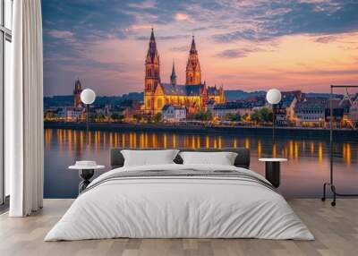 A serene evening at the Mainz Cathedral in Germany, with the cathedral illuminated by warm lights, and the sky transitioning from day to night. Wall mural