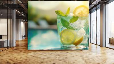 Citrus and mint-infused water in a glass by a sunlit pool, ice cubes floating, fresh lemon slices and mint leaves adding a refreshing touch to the summer scene Wall mural