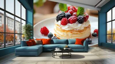 Close-up of fluffy souffle pancakes topped with cream and fresh berries, placed on a white plate on a wooden table, capturing the perfect breakfast treat Wall mural