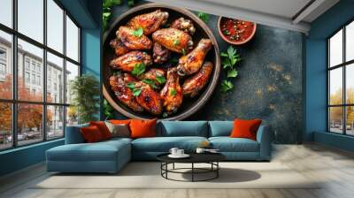 Flat lay of roasted chicken wings on a round plate over a dark stone surface, surrounded by spices and herbs. Ideal for showcasing delicious food preparation Wall mural