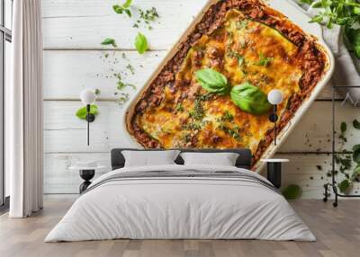 Healthy zucchini lasagna with layers of bolognese sauce in a baking dish, on a white wooden background, sprinkled with fresh herbs, top view, selective focus Wall mural