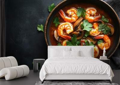 Top view of a bowl of spicy prawn soup, featuring juicy prawns, mushrooms, and a spicy broth, topped with fresh cilantro. Wall mural