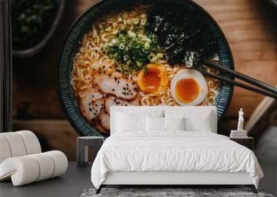 Top view of a ramen bowl with tonkotsu broth, ramen noodles, and a variety of toppings like chashu pork and nori. Wall mural