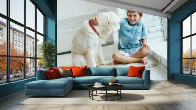 A child with a dog. Little boy with a dog at home.  Wall mural