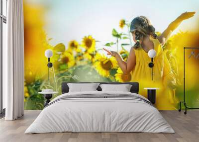 Child in a sunflower field. High quality photo. Wall mural