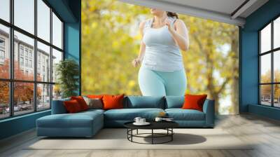 Fat woman and sports. Does exercise for weight loss in the fresh air. High quality photo. Wall mural