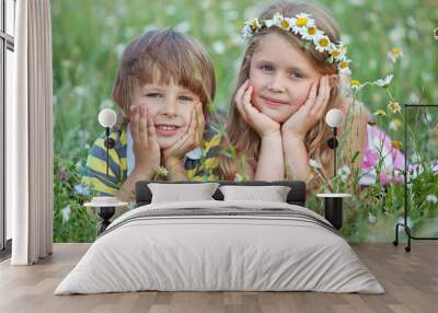 happy kids are relaxing in a camomile field Wall mural